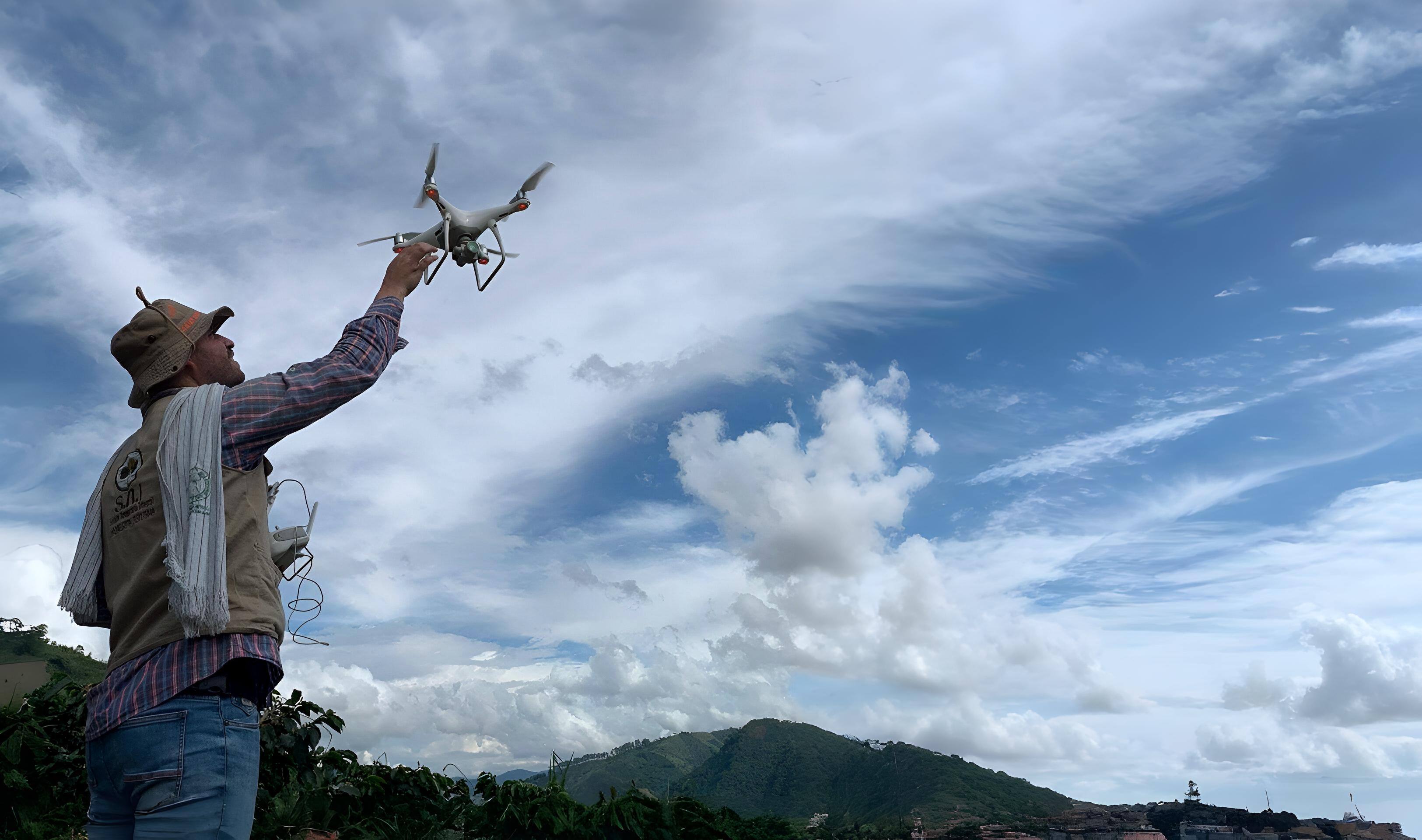 Profesional con dron en campo agrícola